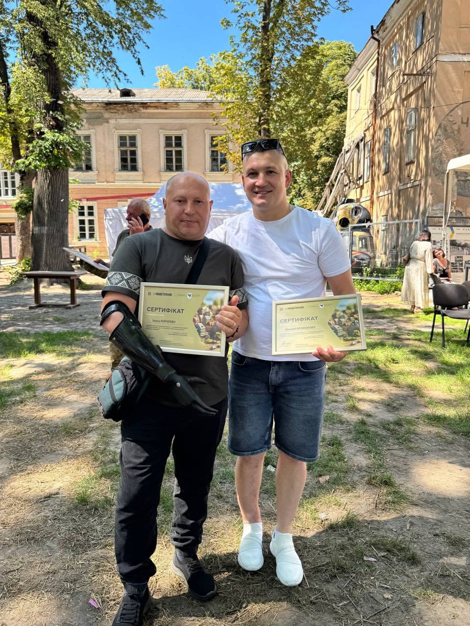 Двоє людей з сертифікатами