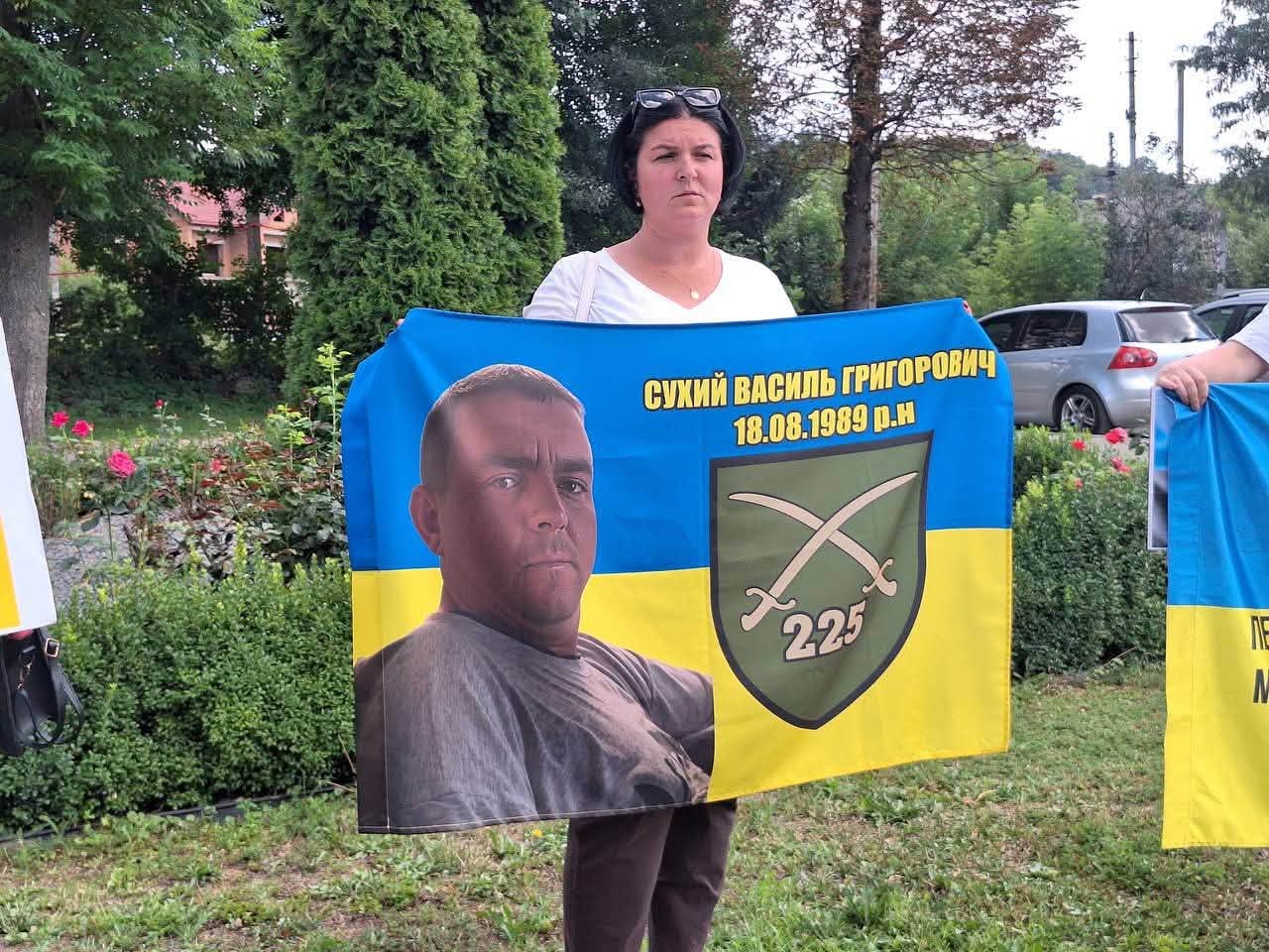 Учасниця акції тримає прапор із фото зниклого військовослужбовця