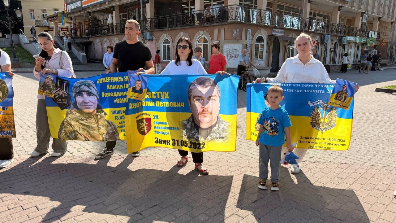 Учасники акції з українськими прапорами та портретами Захисників