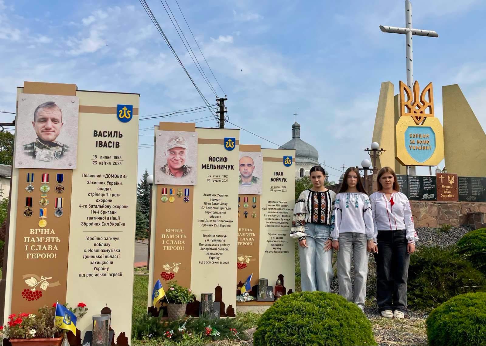 Діти біля меморіалу полеглих Захисників із синьо-жовтими прапорами