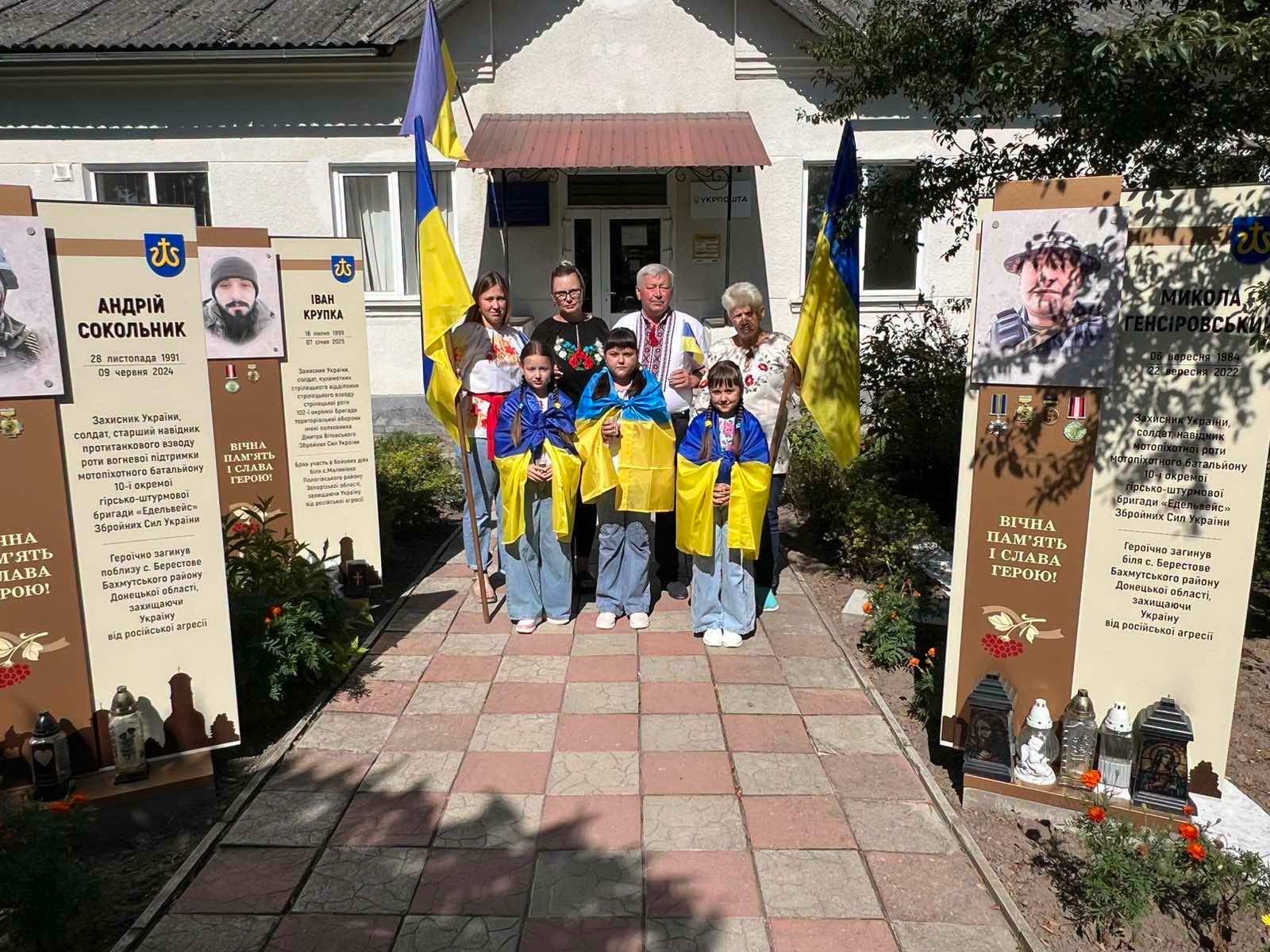 Мешканці громади біля пам’ятних стендів полеглих Захисників України