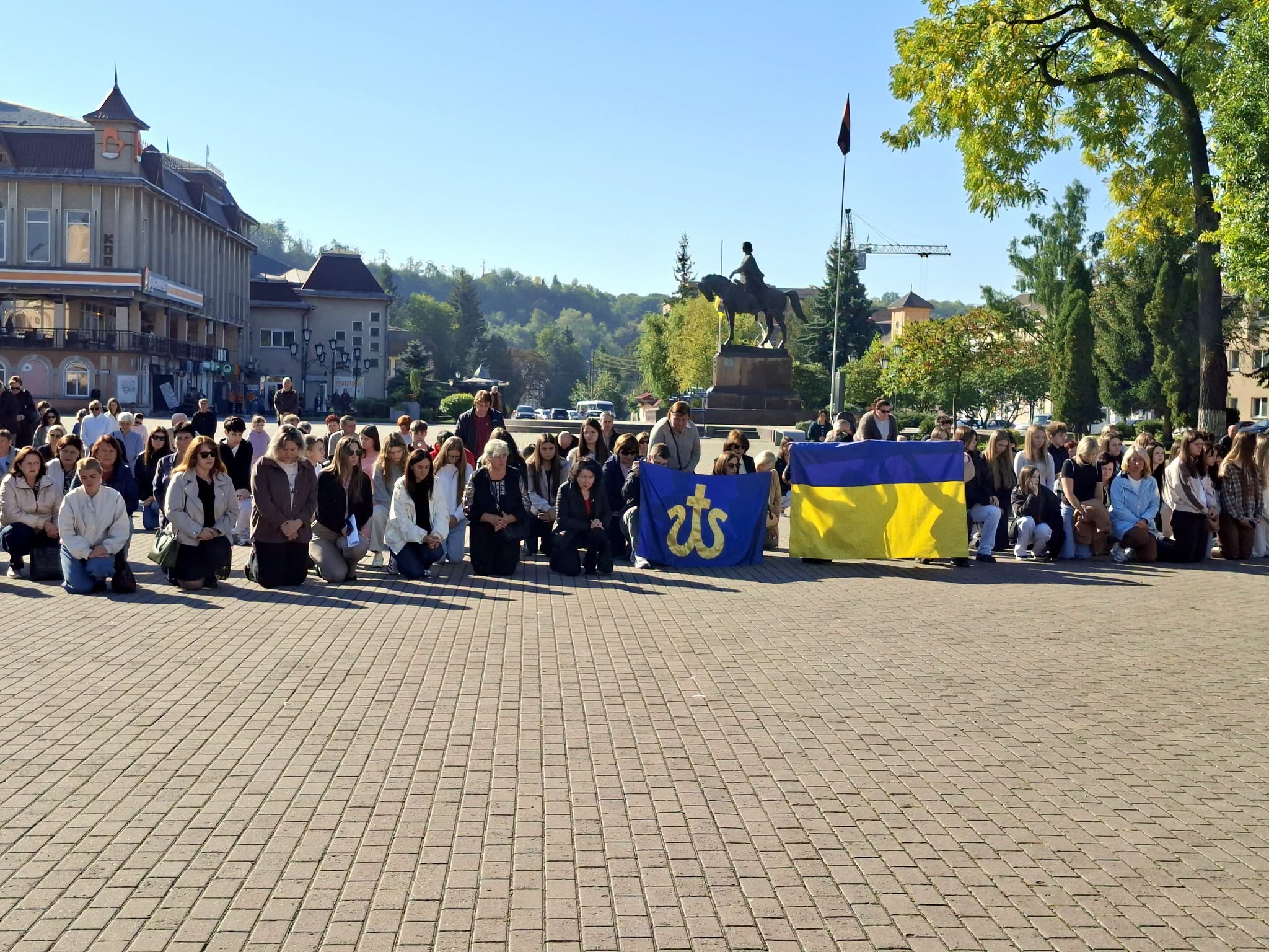 Громада навколішки зусрічає на щиті захисника