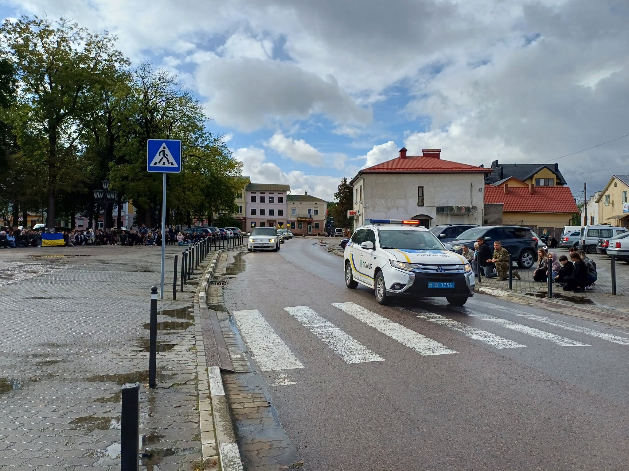 Поліцейський автомобіль супроводжує траурну процесію