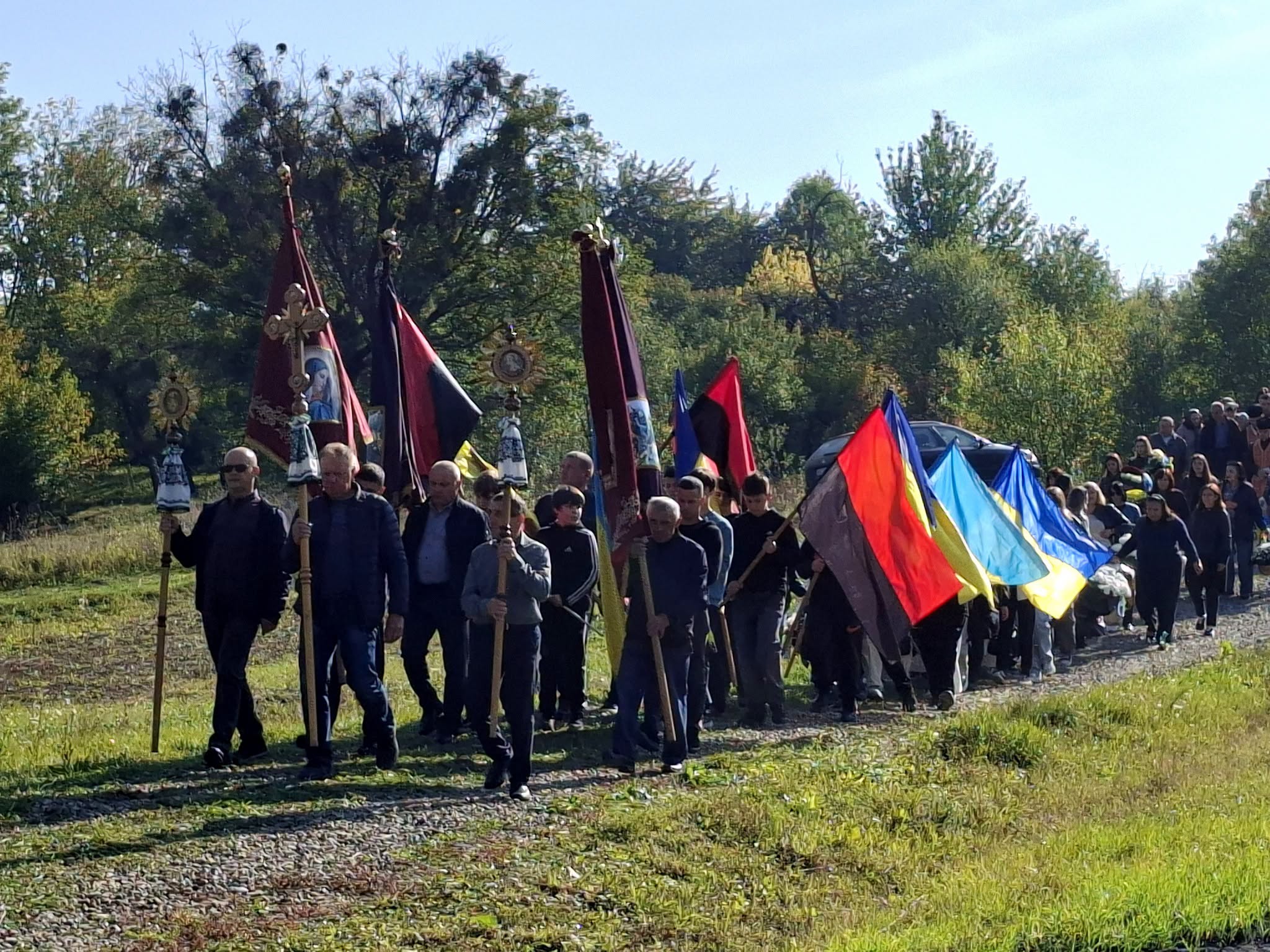 Траурна процесія з українськими прапорами та церковними хоругвами