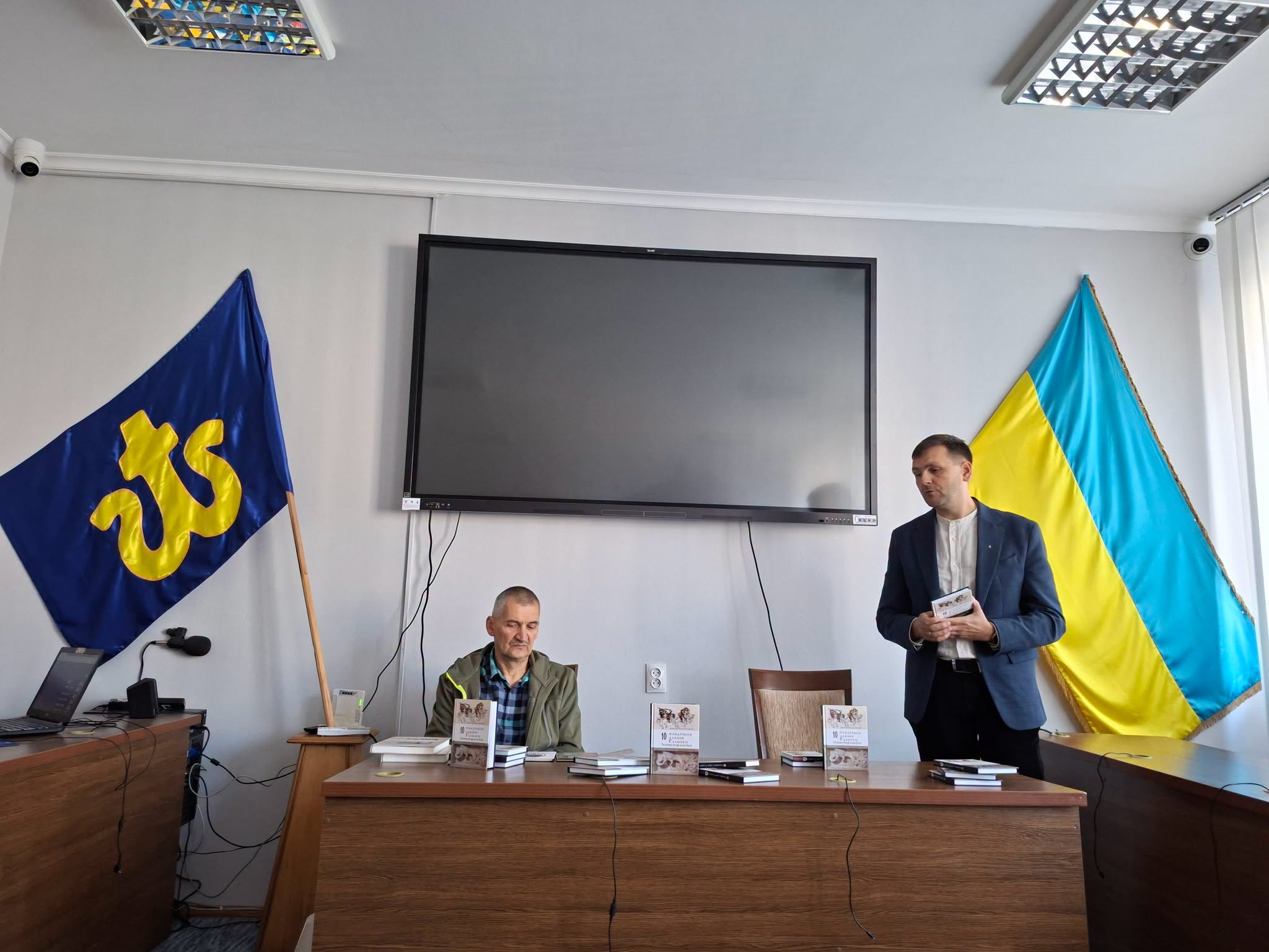 Презентація книги «10 мандрівок давнім Галичем» біля столу з примірниками.
