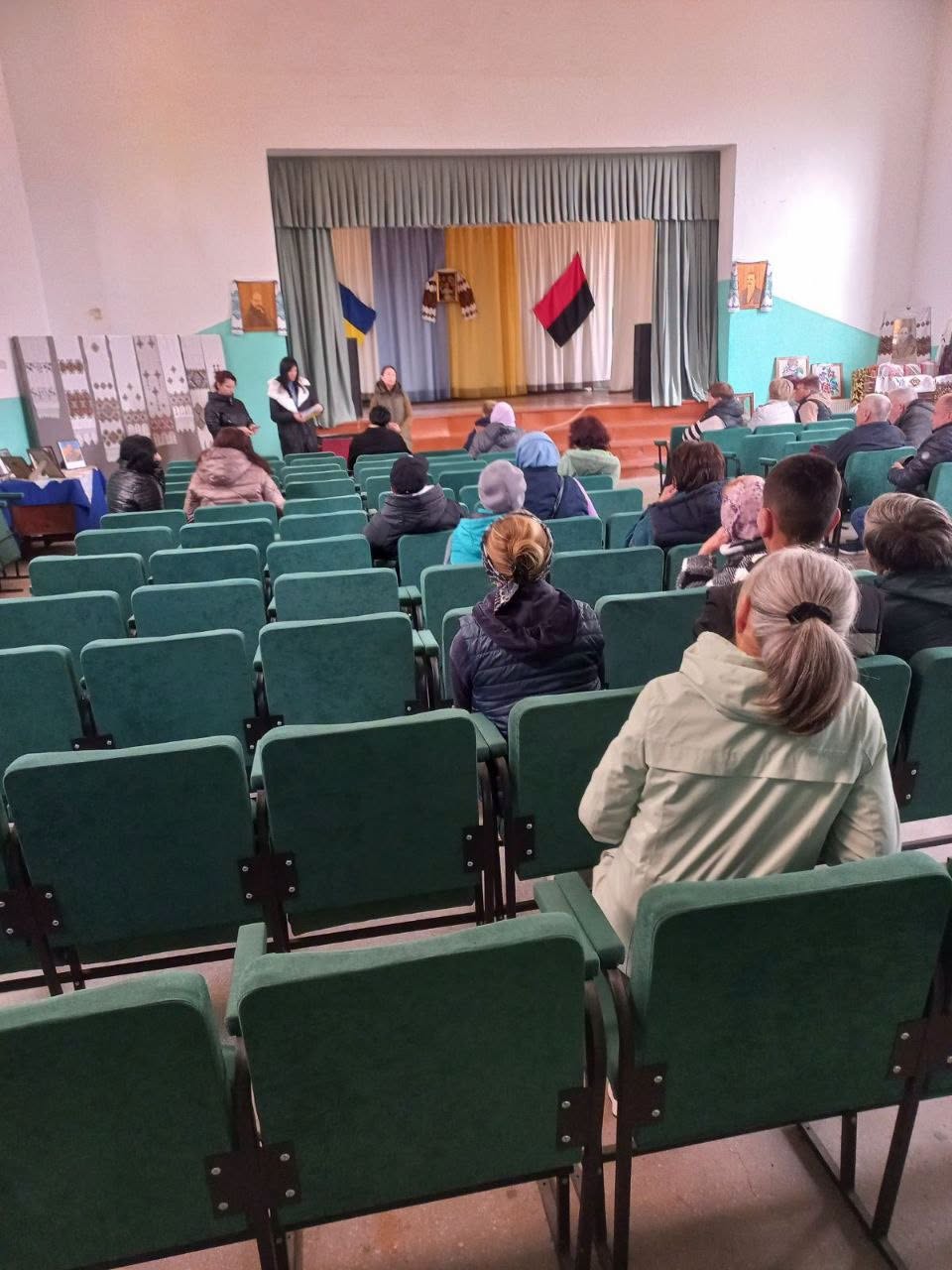 Присутні слухають промовиць перед сценою