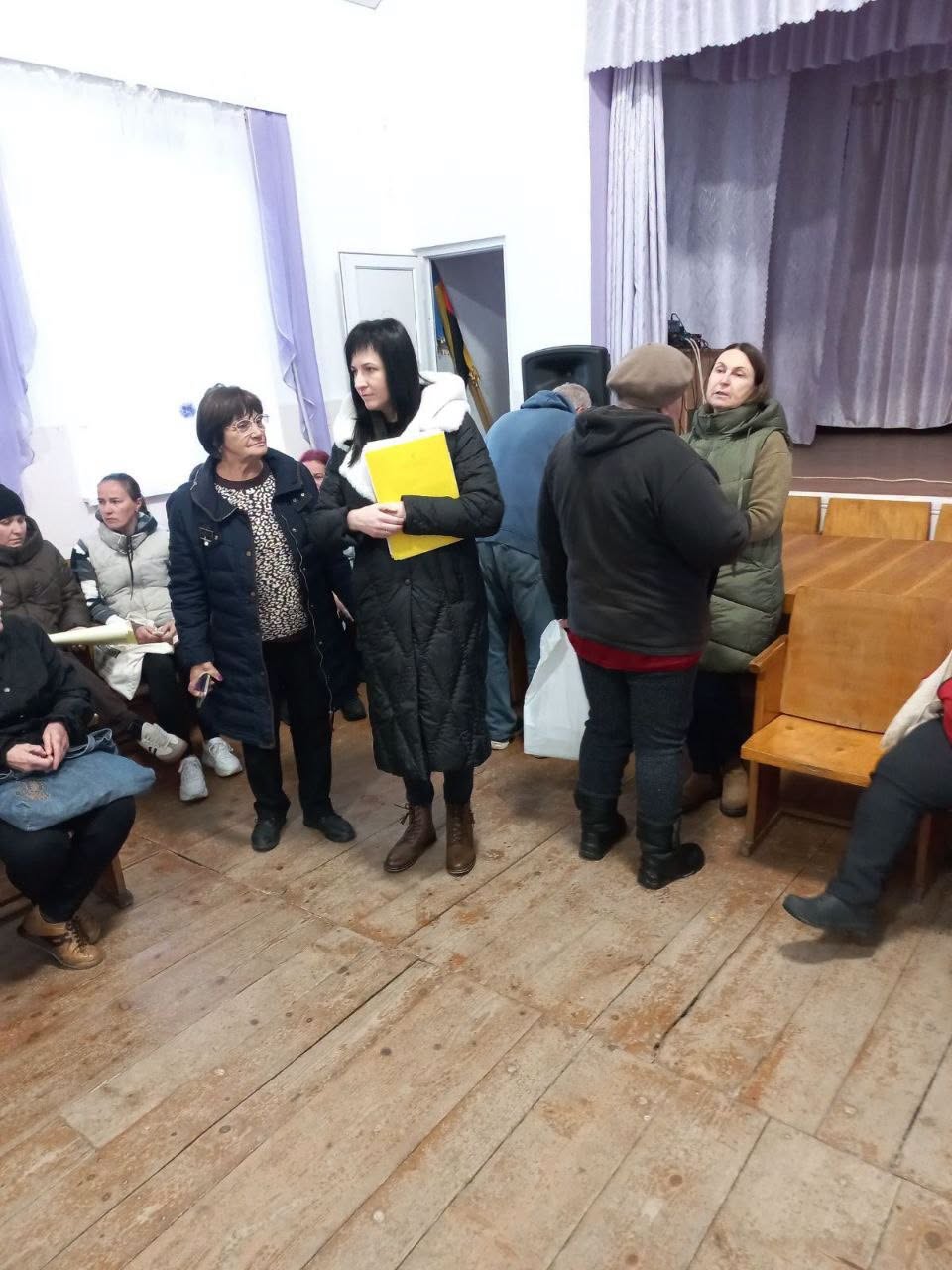 Учасниці зустрічі спілкуються біля сцени