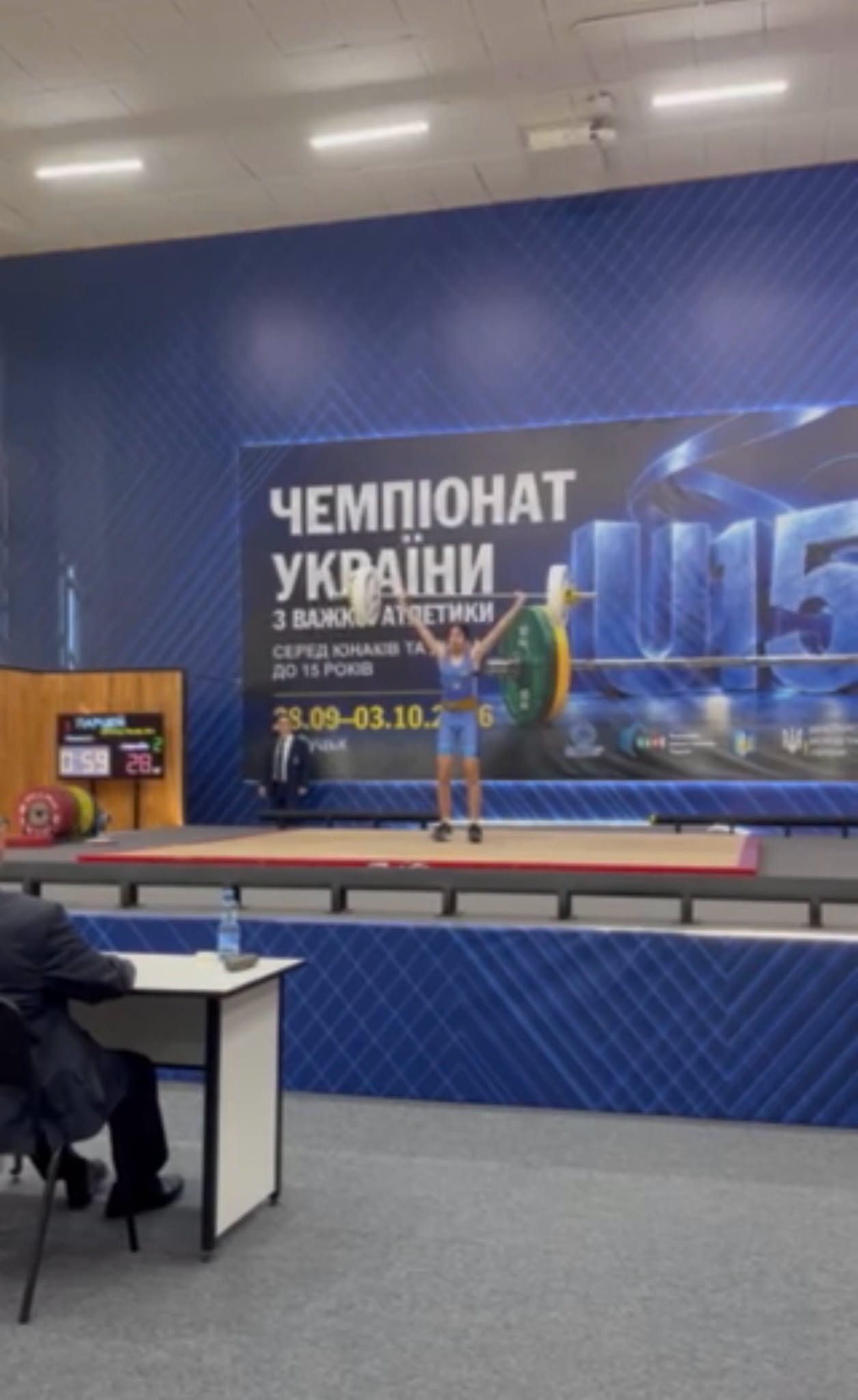 Учасниця чемпіонату України з важкої атлетики виконує вправу зі штангою